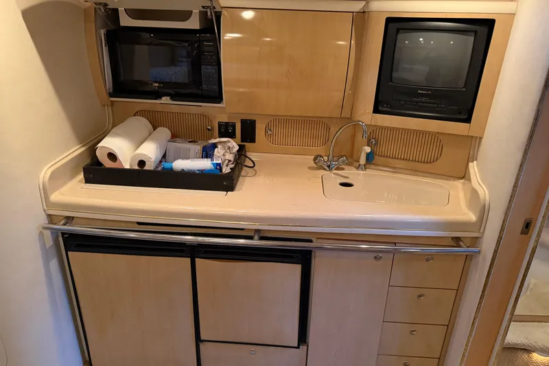 Slide: The Image of 2002 Sea Ray 360 Sundancer galley with sink, microwave, and storage cabinets. - 26