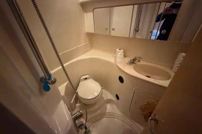 Slide: The Image of Compact bathroom in a 2002 Sea Ray 360 Sundancer yacht, featuring toilet, sink, and shower. - 27