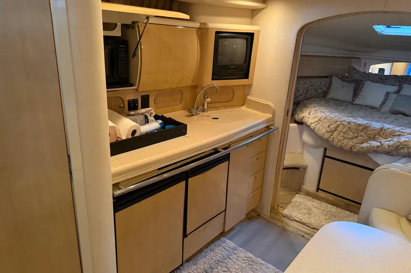 Slide: The Image of Interior of 2002 Sea Ray 360 Sundancer yacht with kitchenette and cozy sleeping area. - 33