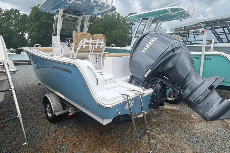 Slide: The Image of 2025 Sportsman Heritage 231 Center Console boat with Yamaha outboard motor, parked on gravel. - 2