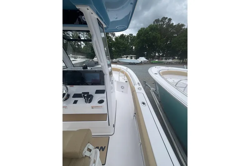 Slide: The Image of 2025 Sportsman Heritage 231 Center Console boat, docked with visible control panel and seating. - 8