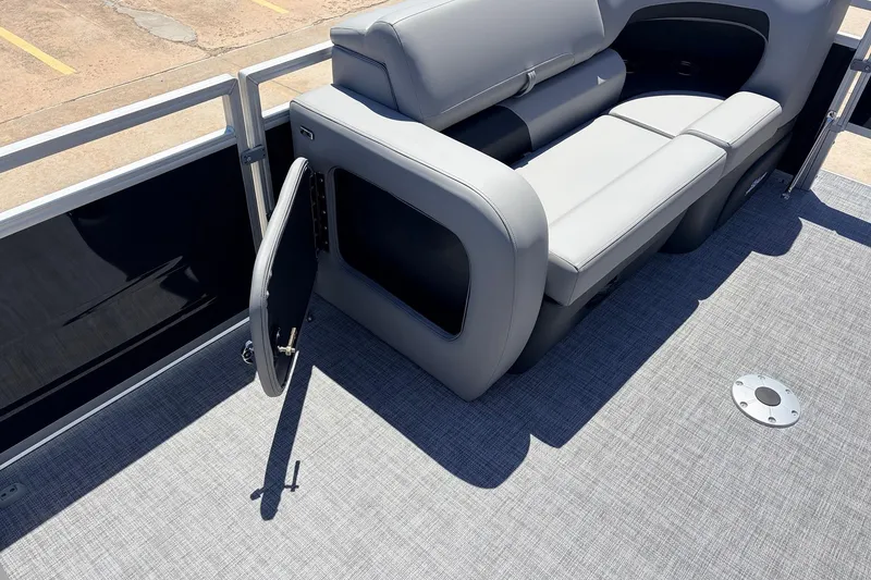 Slide: The Image of 2026 Sun Tracker SportFish 22 DLX pontoon boat interior with gray seating and open storage compartment. - 17