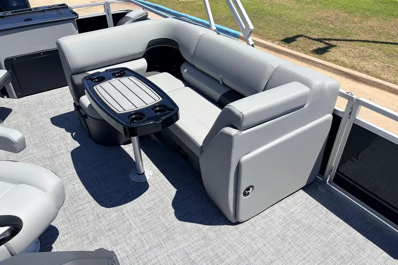 Slide: The Image of 2026 Sun Tracker SportFish 22 DLX boat interior with gray seating and table. - 25