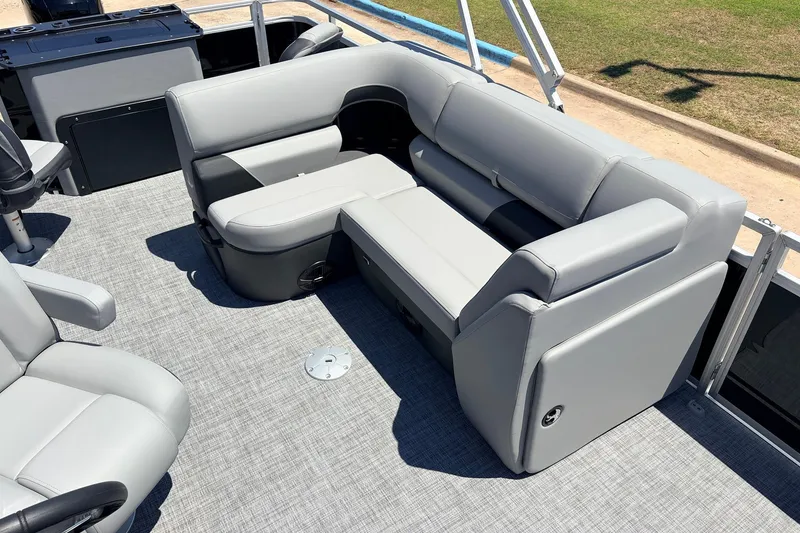 Slide: The Image of 2026 Sun Tracker SportFish 22 DLX boat interior with gray seating and carpeted flooring. - 26