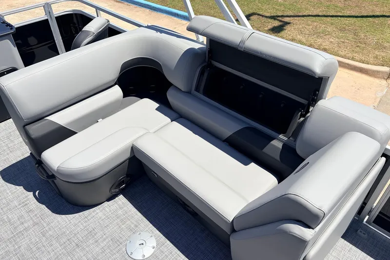 Slide: The Image of 2026 Sun Tracker SportFish 22 DLX boat interior with gray cushioned seating and storage compartment. - 27