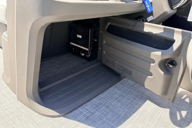 Slide: The Image of 2026 Sun Tracker SportFish 22 DLX storage compartment with open door and visible interior. - 36