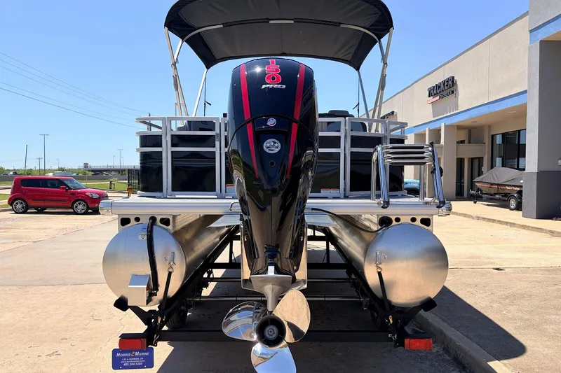Slide: The Image of 2026 Sun Tracker SportFish 22 DLX pontoon boat with powerful outboard motor, parked outdoors. - 7