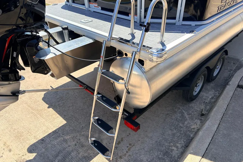 Slide: The Image of 2026 Sun Tracker SportFish 22 DLX pontoon boat with ladder and outboard motor. - 9