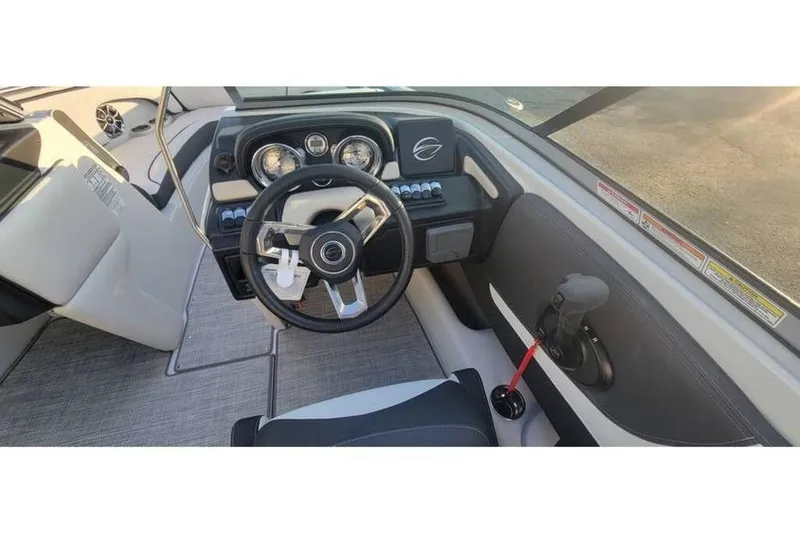 Slide: The Image of 2024 Crownline 210 SS boat interior with steering wheel and dashboard controls. - 19