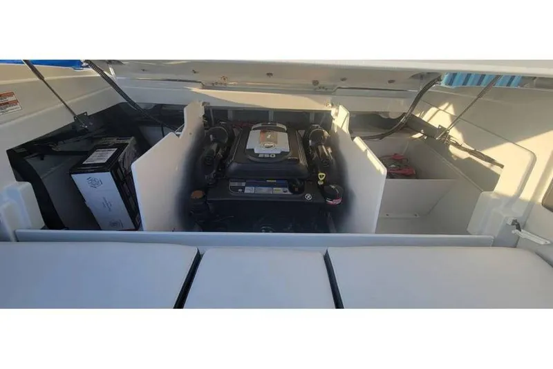 Slide: The Image of 2024 Crownline 210 SS boat engine compartment, showcasing the engine and battery setup. - 8