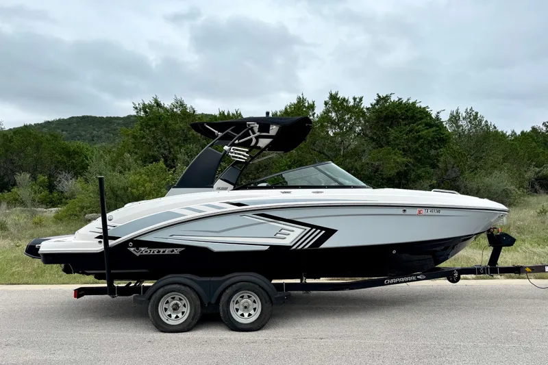 Slide: The Image of 2019 Chaparral Vortex 223 VRX boat on trailer, parked on road with trees in background. - 10