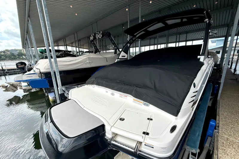Slide: The Image of 2019 Chaparral Vortex 223 VRX boat docked under a covered marina. - 19
