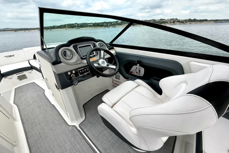Slide: The Image of 2019 Chaparral Vortex 223 VRX boat interior with steering wheel and seating, overlooking water. - 25