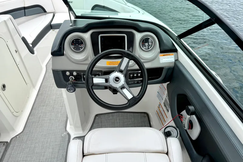 Slide: The Image of 2019 Chaparral Vortex 223 VRX boat cockpit with steering wheel and dashboard controls. - 26