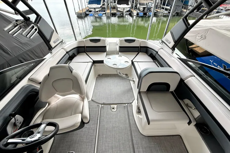 Slide: The Image of 2019 Chaparral Vortex 223 VRX boat interior with seating and table, docked at marina. - 33