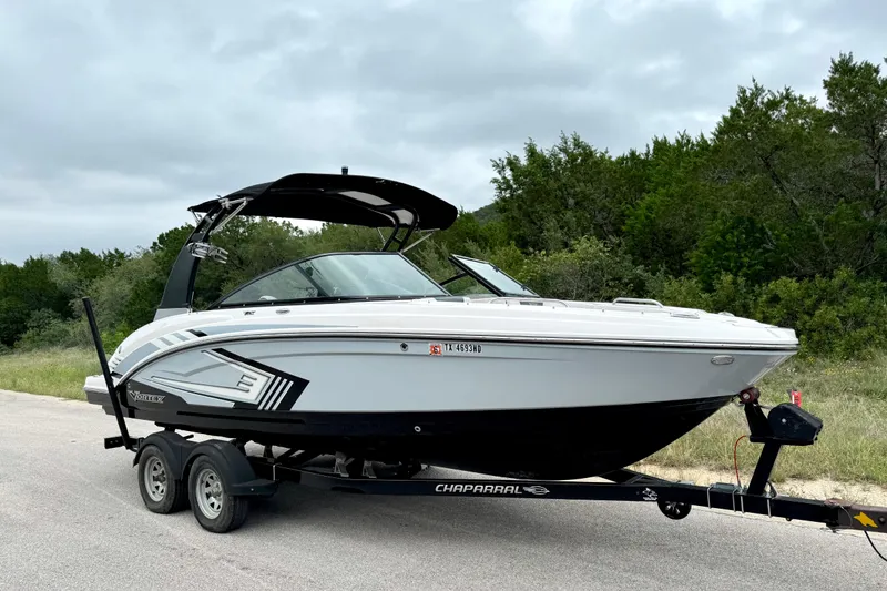 Slide: The Image of 2019 Chaparral Vortex 223 VRX boat on trailer, parked on roadside with trees in background. - 9