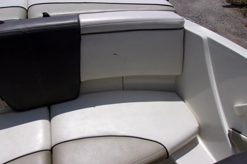 Slide: The Image of Interior seating of a 2007 Sea Ray 185 Sport boat, featuring white and black upholstery. - 12