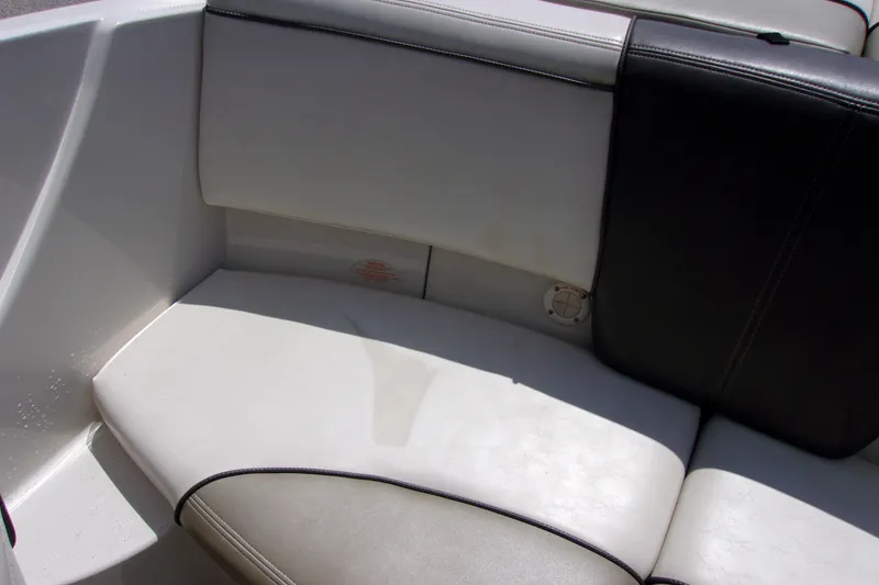 Slide: The Image of 2007 Sea Ray 185 Sport boat interior seating, featuring white and black upholstery. - 13
