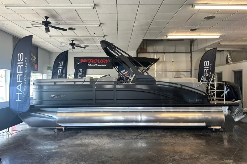The Image of 2026 Harris Solstice 230 CWDH pontoon boat displayed indoors with Mercury engine banners. - 1