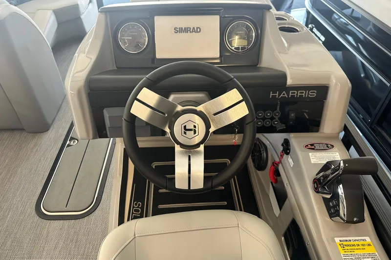 Slide: The Image of 2026 Harris Solstice 230 CWDH boat dashboard with steering wheel and Simrad display. - 8