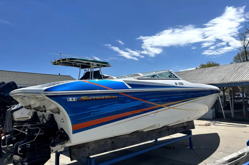 Slide: The Image of 2007 Sunsation 32 Dominator speedboat with vibrant blue and orange design on display. - 2