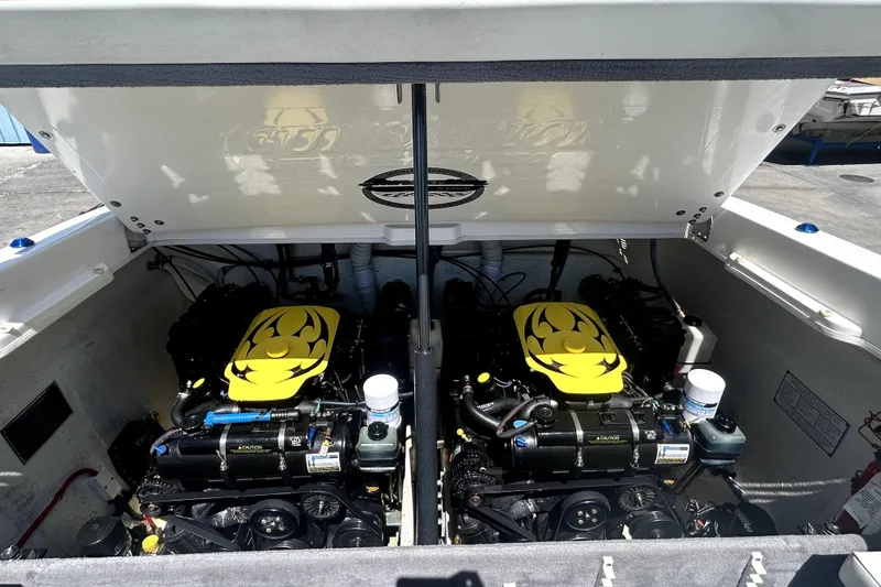 Slide: The Image of 2007 Sunsation 32 Dominator boat engine compartment with dual engines and yellow covers. - 28