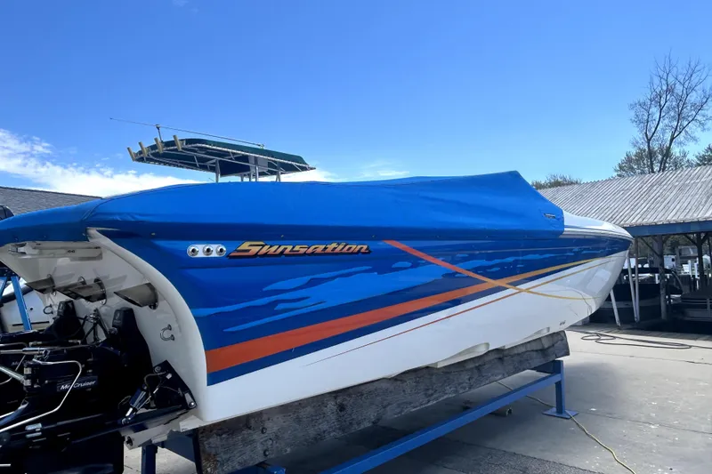 Slide: The Image of 2007 Sunsation 32 Dominator boat with blue cover, docked outdoors. - 30