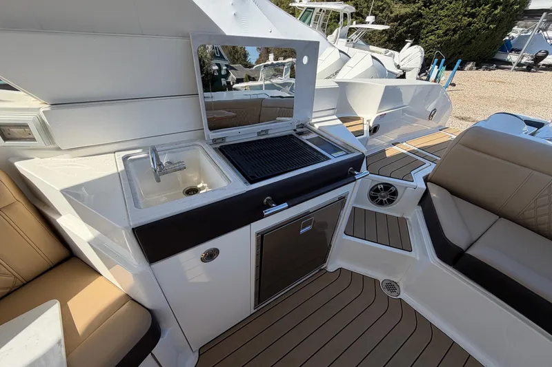 Slide: The Image of 2023 Sea Ray SLX 350 Outboard boat interior with sink, grill, and seating area. - 14
