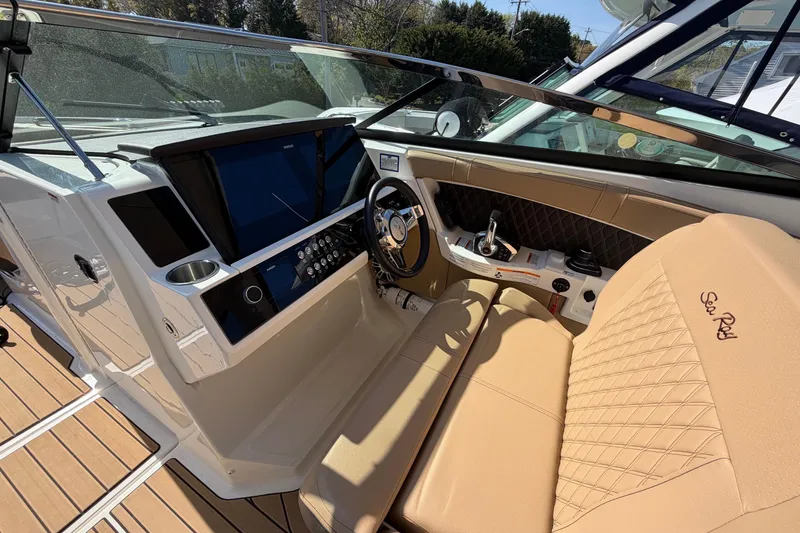 Slide: The Image of Luxurious 2023 Sea Ray SLX 350 Outboard helm with tan leather seating and modern controls. - 17