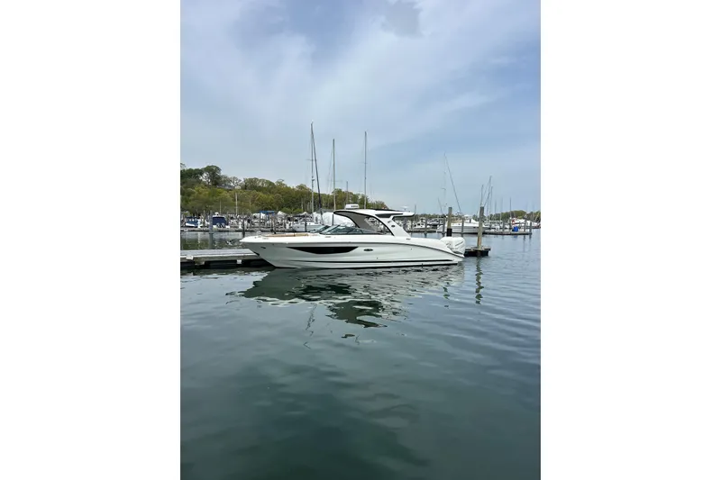 Slide: The Image of 2023 Sea Ray SLX 350 Outboard boat docked in a serene marina setting. - 26