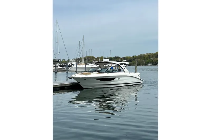 Slide: The Image of 2023 Sea Ray SLX 350 Outboard docked in a marina, calm water, clear sky. - 27