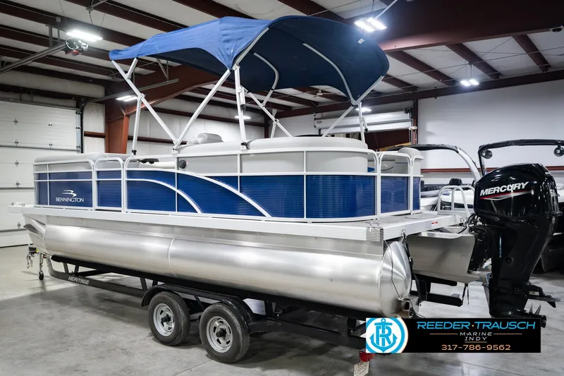Slide: The Image of 2021 Bennington 22 SVSR pontoon boat with blue canopy in indoor showroom. - 10