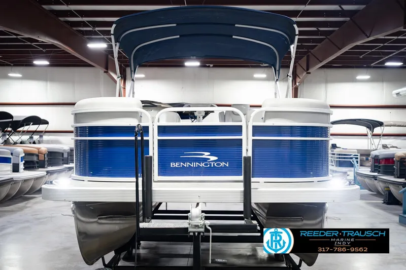 Slide: The Image of 2021 Bennington 22 SVSR pontoon boat in showroom, featuring blue and white design. - 4