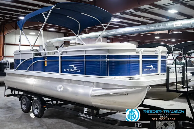 Slide: The Image of 2021 Bennington 22 SVSR pontoon boat with blue exterior on a trailer in a showroom. - 5