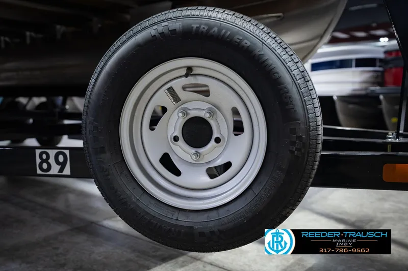 Slide: The Image of Trailer wheel of a 2021 Bennington 22 SVSR boat, displayed indoors. - 63