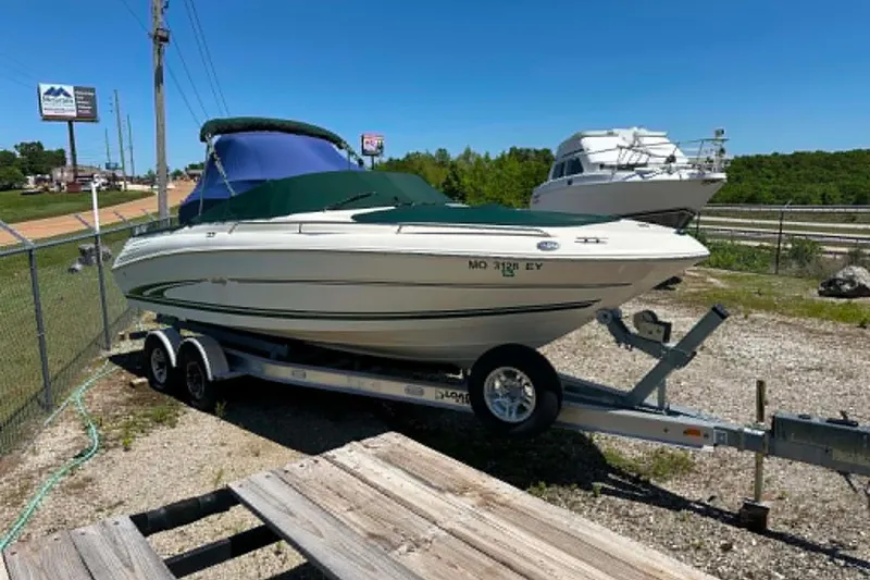 The Image of 2001 Sea Ray 260 Bow Rider on trailer, parked outdoors under clear blue sky. - 0