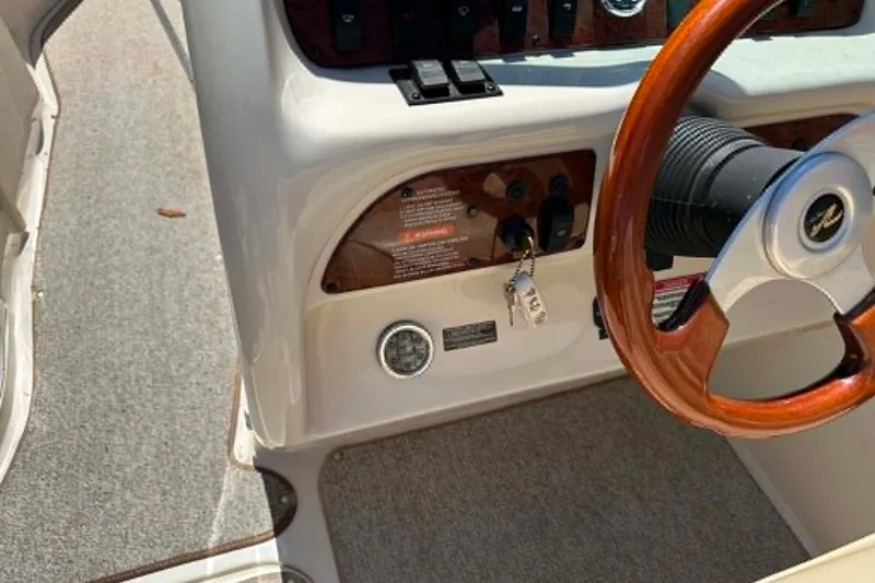 Slide: The Image of 2001 Sea Ray 260 Bow Rider dashboard with wooden steering wheel and control panel. - 16