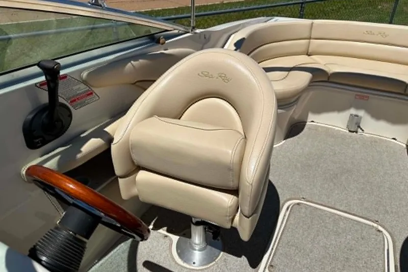 Slide: The Image of 2001 Sea Ray 260 Bow Rider interior with beige seating and steering wheel. - 18
