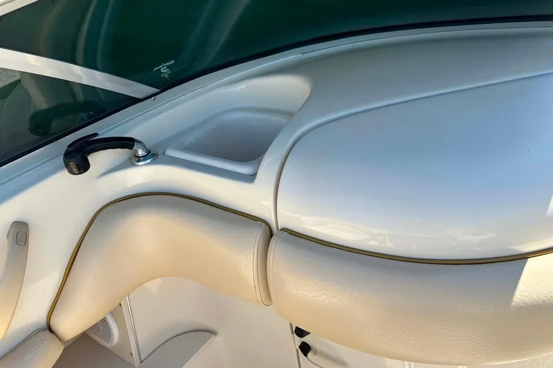 Slide: The Image of Interior view of a 2001 Sea Ray 260 Bow Rider boat, featuring beige seating and a cup holder. - 29