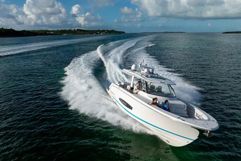 Slide: The Image of 2026 Regal 43 SAV cruising on open water under a partly cloudy sky. - 2