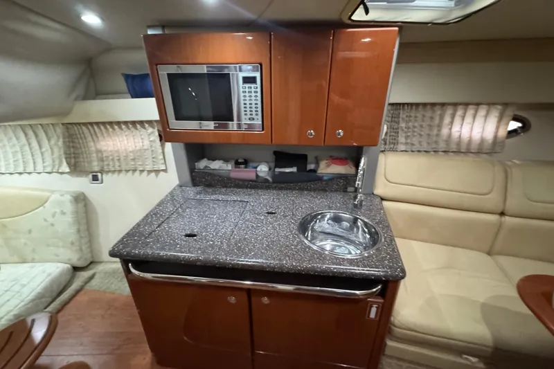 Slide: The Image of 2008 Formula 350 Sun Sport interior with kitchenette, featuring microwave, sink, and seating area. - 21