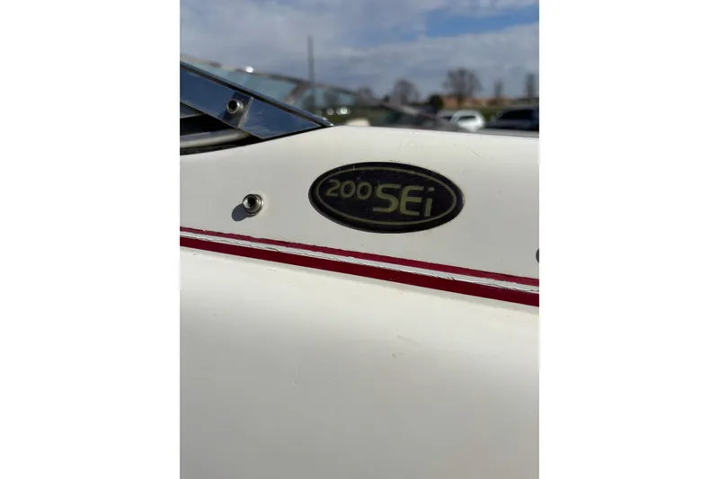 Slide: The Image of 1993 Larson SEi 200 Cuddy I/O boat emblem with red stripe detail. - 24