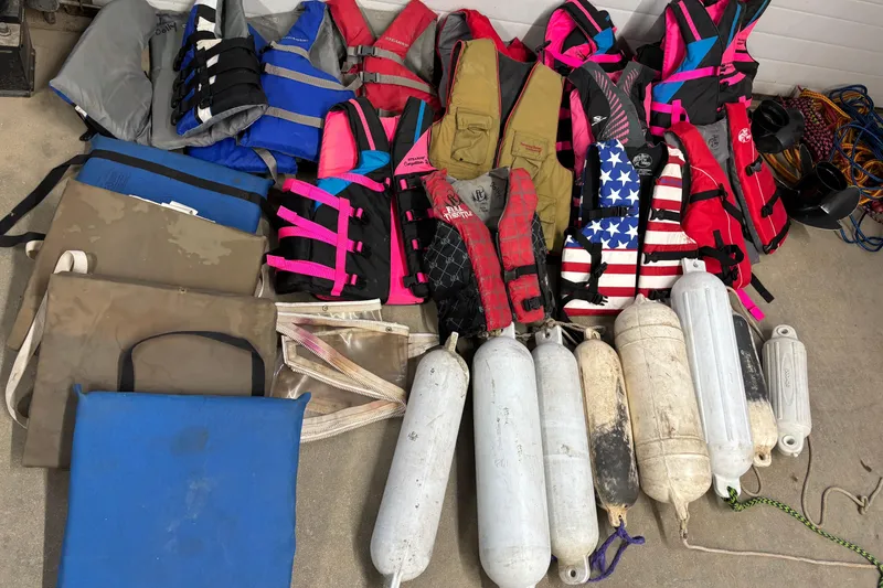 Slide: The Image of Assorted life jackets and boat fenders on concrete, suitable for Larson SEi 200 Cuddy I/O. - 27