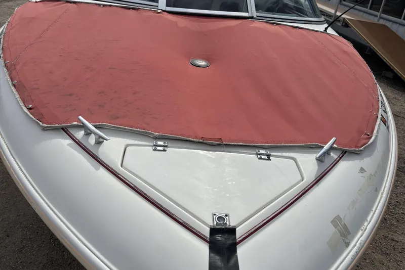 Slide: The Image of 1993 Larson SEi 200 Cuddy I/O boat with red cover, front view. - 29