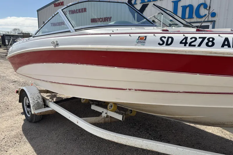 Slide: The Image of 1993 Larson SEi 200 Cuddy I/O boat with red and white hull on trailer. - 4