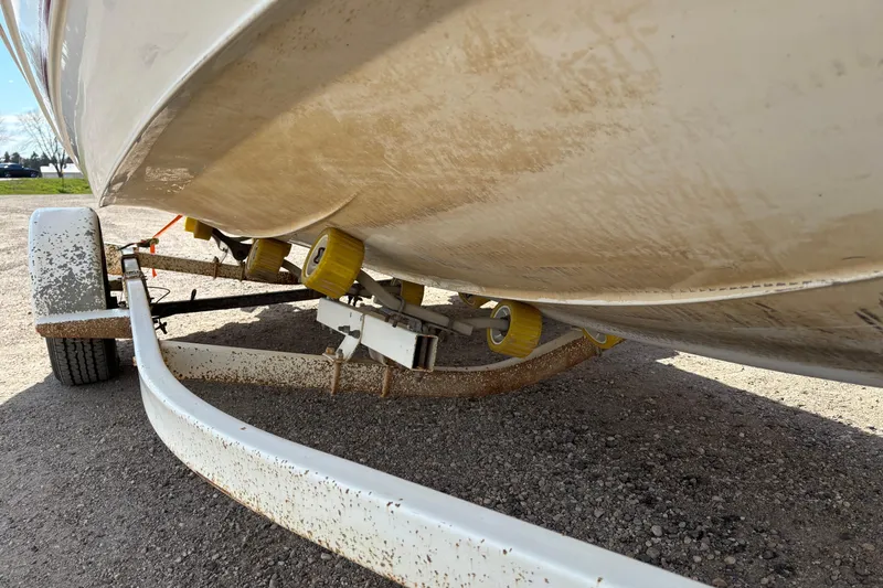 Slide: The Image of 1993 Larson SEi 200 Cuddy I/O boat on a trailer, showing hull and rollers. - 9