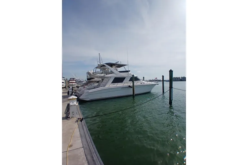 The Image of 1996 Sea Ray 550 Sedan Bridge yacht docked at marina under clear sky. - 0