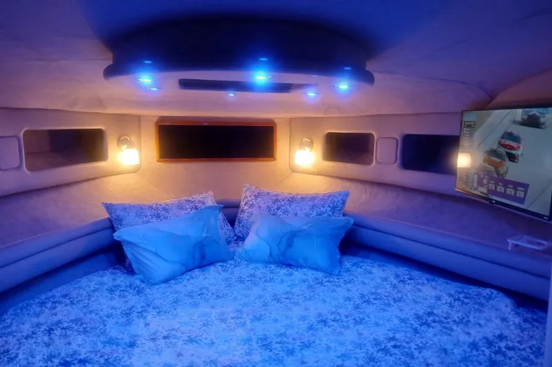 Slide: The Image of Luxurious 1996 Sea Ray 550 Sedan Bridge cabin with cozy bedding and ambient lighting. - 10