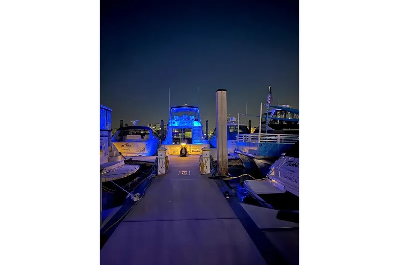Slide: The Image of 1996 Sea Ray 550 Sedan Bridge yacht illuminated with blue lights at night dock. - 3