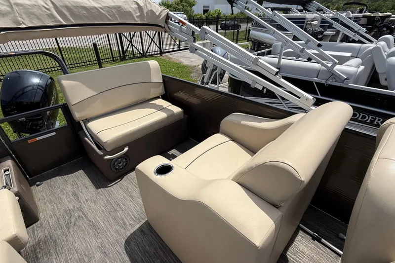 Slide: The Image of 2022 Crest Classic LX 220 pontoon boat interior with beige seating and cup holders. - 10